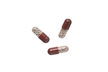 Brown and transparent plastic capsule pills,  Isolated on a white background.
