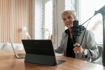 The radio host transmits the news in the morning. The journalist is an adult gray-haired man....