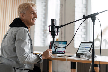 Workplace in the recording studio. The blogger is blogging communication with clients. A journalist aged microphone is a gray-haired man. The radio host transmits the news in the morning.