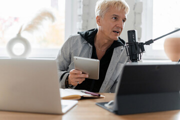 The radio host transmits the news in the morning. A journalist aged microphone is a gray-haired...