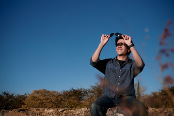 Joven con lentes mirando el atardecer