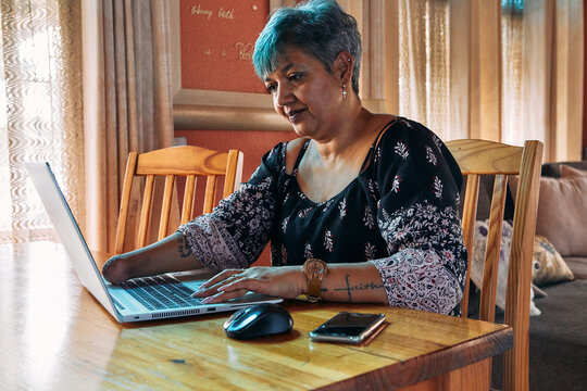 One-armed woman working on laptop at home