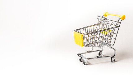 Miniature shopping cart isolated on a gray background with copy space