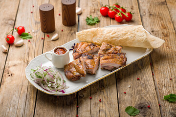 chicken kebab on plate with sauce on wooden table