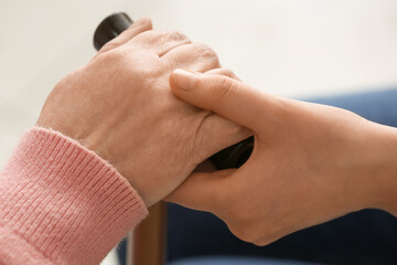 Young woman holding hand of grandmother, closeup