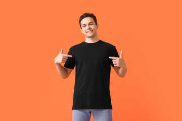 Handsome young man in stylish t-shirt on color background