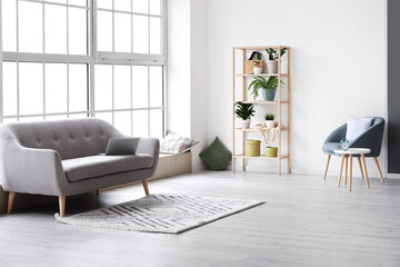 Interior of living room with sofa, shelving unit and houseplants