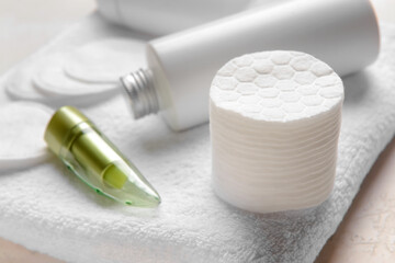 Cotton pads, care cosmetics and towel on table, closeup