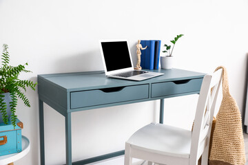 Stylish workplace near wall in room