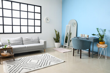Modern living room interior with stylish mirror, sofa and armchair