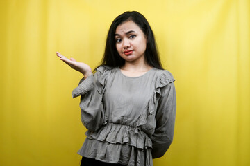 Beautiful young woman with hands presenting something on empty space, isolated
