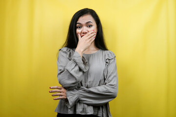 Beautiful young woman surprised, shocked, with hands covering mouth, isolated