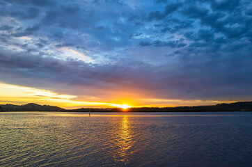 Sunrise waterscape with colourful cloud covered sky
