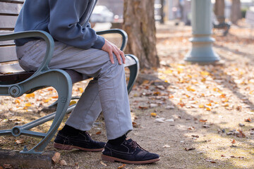 公園のベンチから立ち上がれない男性　
膝が痛そうな男性　