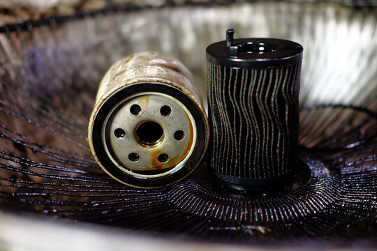 Car oil filter is very dirty and oil stains background