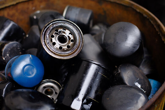 Car oil filter is very dirty and oil stains background