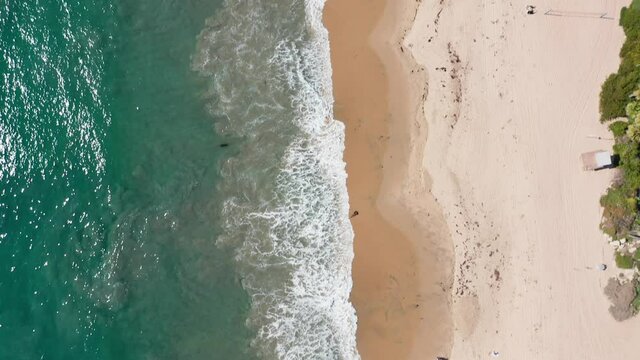 tropical summer seascape, green turquoise water breaking on sandy beach. Bird eyes view
