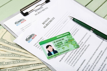 Fototapeta na wymiar Clipboard with rental agreements, pen, driver license and money on color wooden background, closeup
