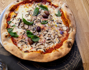 Mushroom pizza with crunchy looking crust on wooden table in Croatia. 