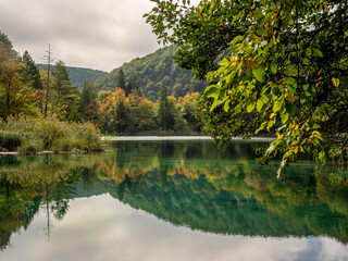 Beautiful reflection of trees and mountains in one of the lakes of the Plitvice Lakes District in Croatia. 