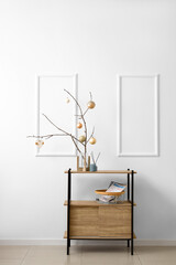 Tree branches with Christmas balls in stylish room interior