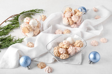 Glass bowls with tasty meringues on white background