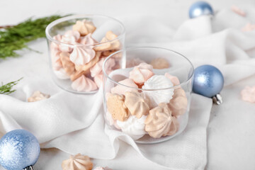 Fototapeta na wymiar Glass bowls with tasty meringues on white background