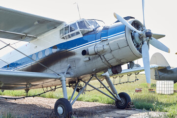 A Soviet-era aircraft in good condition is standing in a field