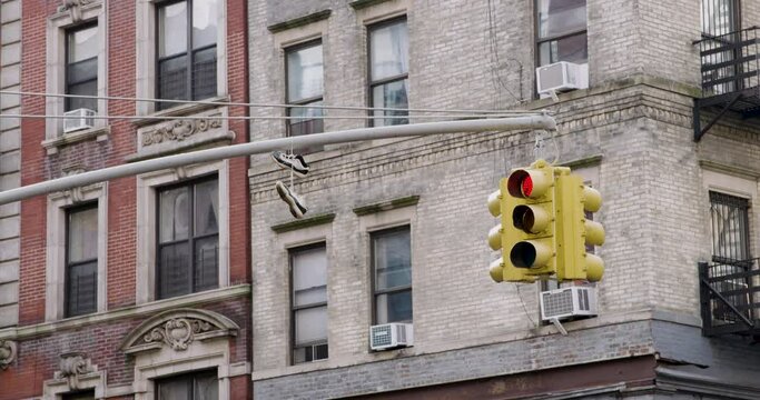 Sneakers On Traffic Signal With New York City Apartment Buildings In Background