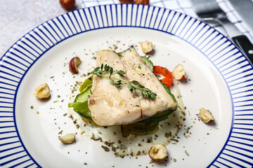 Plate of delicious sea bass fish on table, closeup