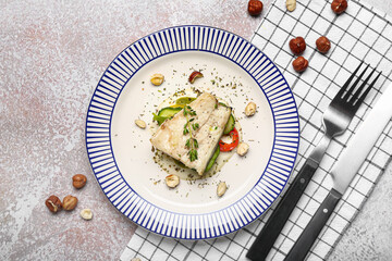 Plate of delicious sea bass fish on light background