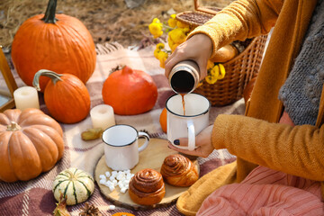 Young woman having romantic picnic on autumn day