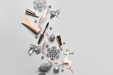 Makeup cosmetics and Christmas decor on light background