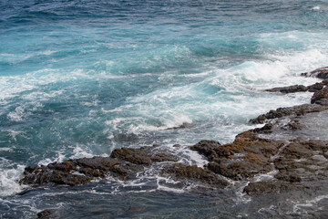 Splashing waves on the rock in the sea. Wave hit the stone in the ocean with a tube background.