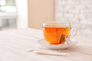 Glass cup of hot tea on table in cafe