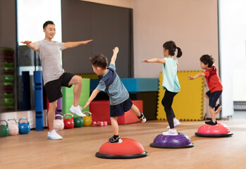 Cute children having exercise class in gym