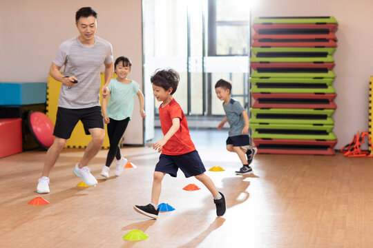 Cute children having exercise class in gym