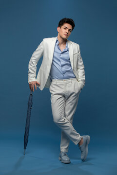 Studio shot of fashionable young Chinese man with an umbrella