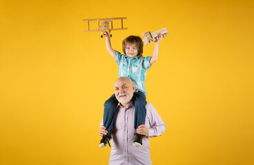 Grandson child and grandfather with toy plane and wooden toy truck. Men generation granddad and grandchild. Elderly old relative with child.