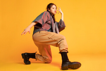 Studio shot of fashionable young woman dancing