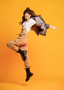 Studio shot of fashionable young woman dancing