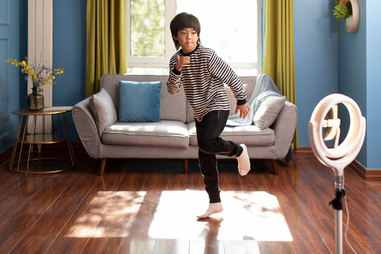 Little Chinese boy doing live webcast at home