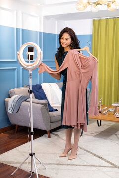 Young Chinese woman doing live webcast at home