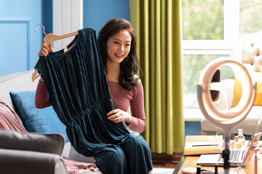 Young Chinese woman doing live webcast at home
