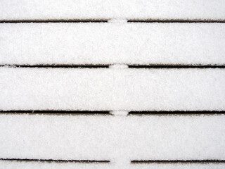 Wooden boards covered with a thin layer of first snow. First snow.