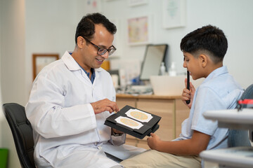Wide shot of optical staff or ophthalmologist use test book of color blindness for testing Indian...