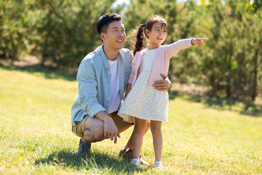 Happy father and daughter relaxing on meadow