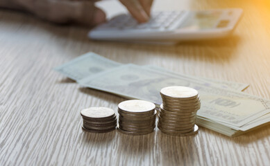 Saving concept,stack of coin money on table and hand working background,soft focus.