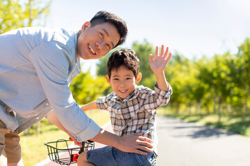 Father teaching son to ride bike
