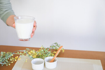 牛乳が入ったグラスを持った手元